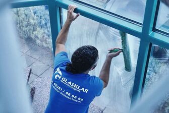 Mitarbeiter der GLASKLAR Gebäudereinigung bei der Fensterreinigung